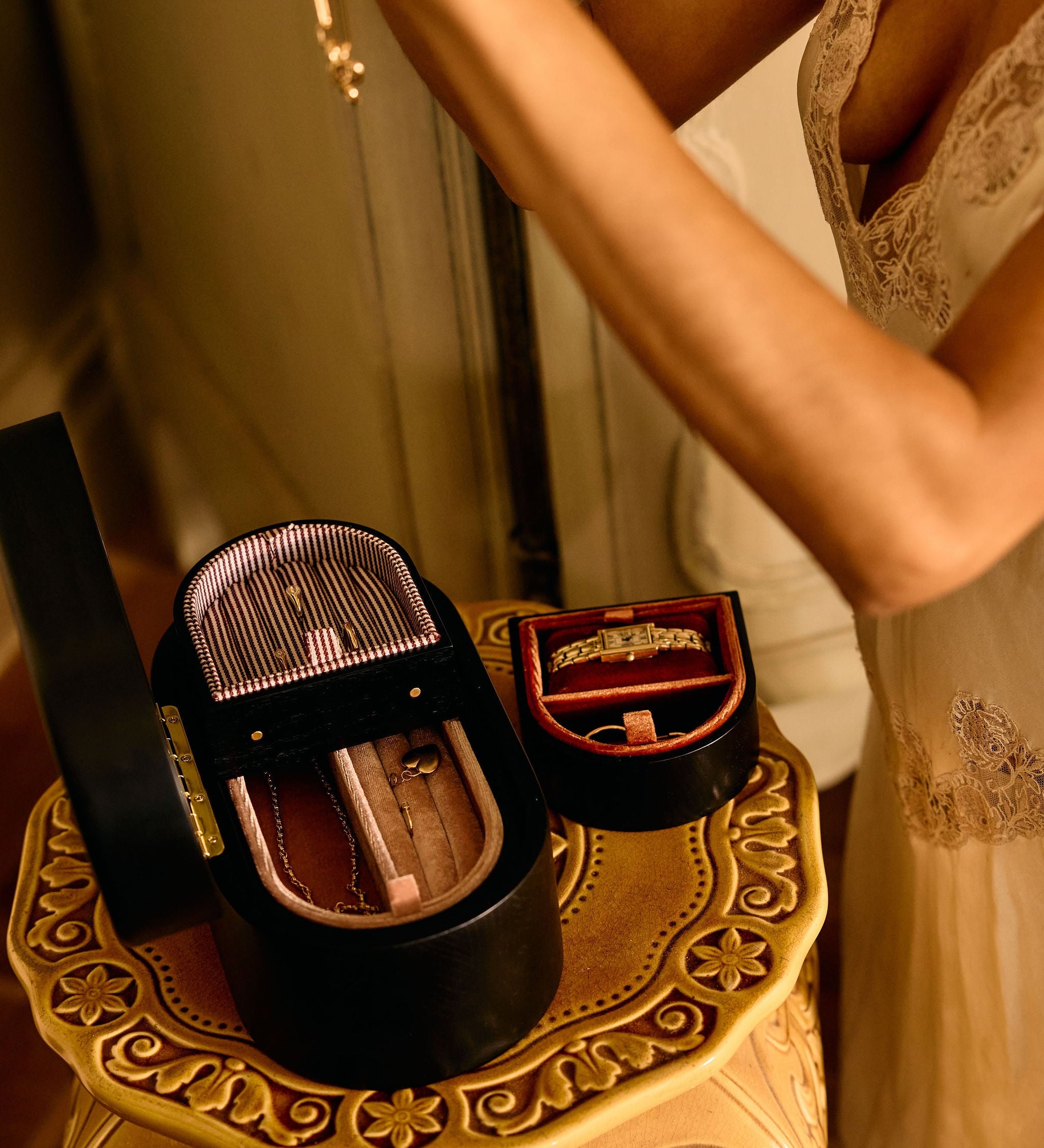 Close-up of a decorative box with a mirror on a small table, with a person partially visible in the background.