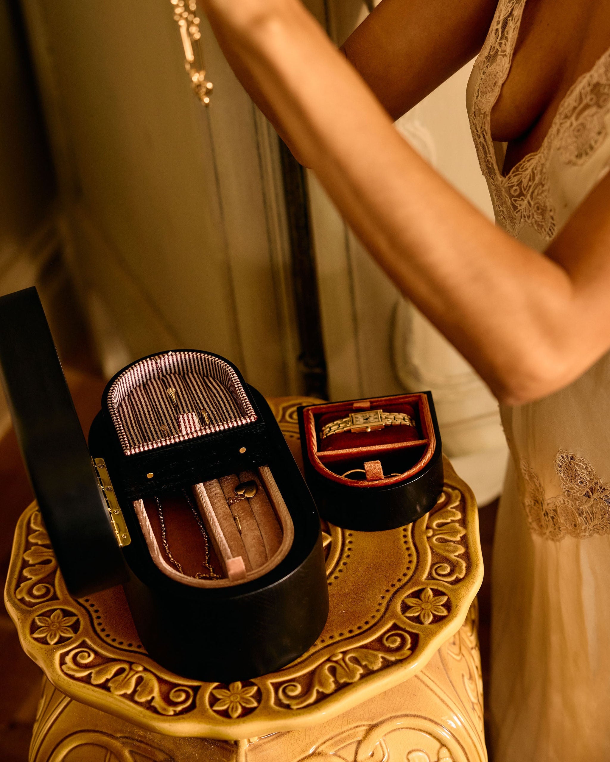 Close-up of a decorative box with a mirror on a small table, with a person partially visible in the background.