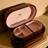 Open jewelry box with a pink interior on a beige background