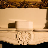 Decorative fireplace mantel with a gold-framed mirror above it.