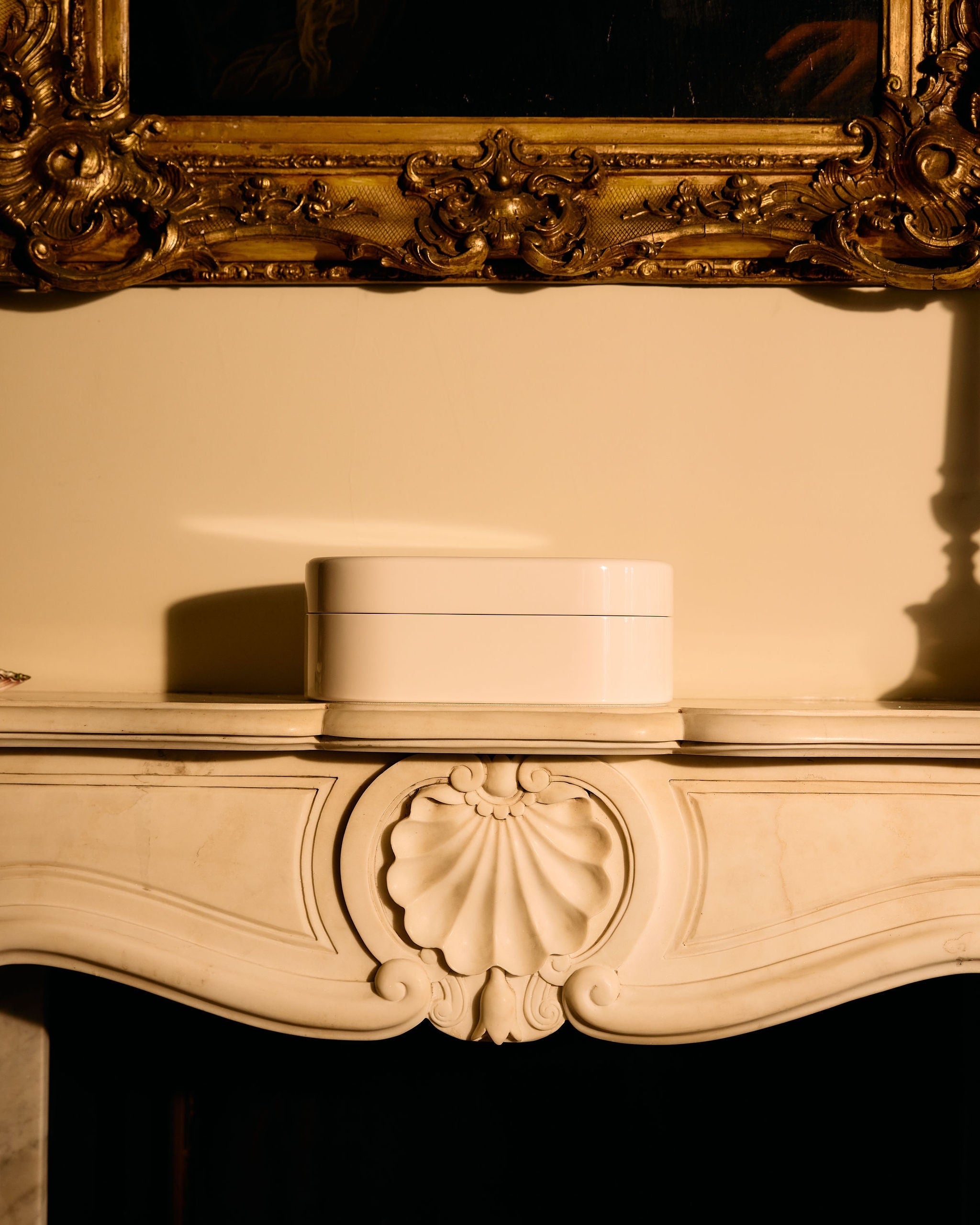 Decorative fireplace mantel with a gold-framed mirror above it.