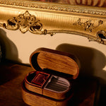 Wooden jewelry box with cards on a wooden surface, ornate gold frame in the background