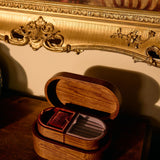 Wooden jewelry box with cards on a wooden surface, ornate gold frame in the background