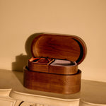 Wooden jewelry box on a decorative surface with a beige wall in the background