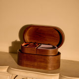 Wooden jewelry box on a decorative surface with a beige wall in the background